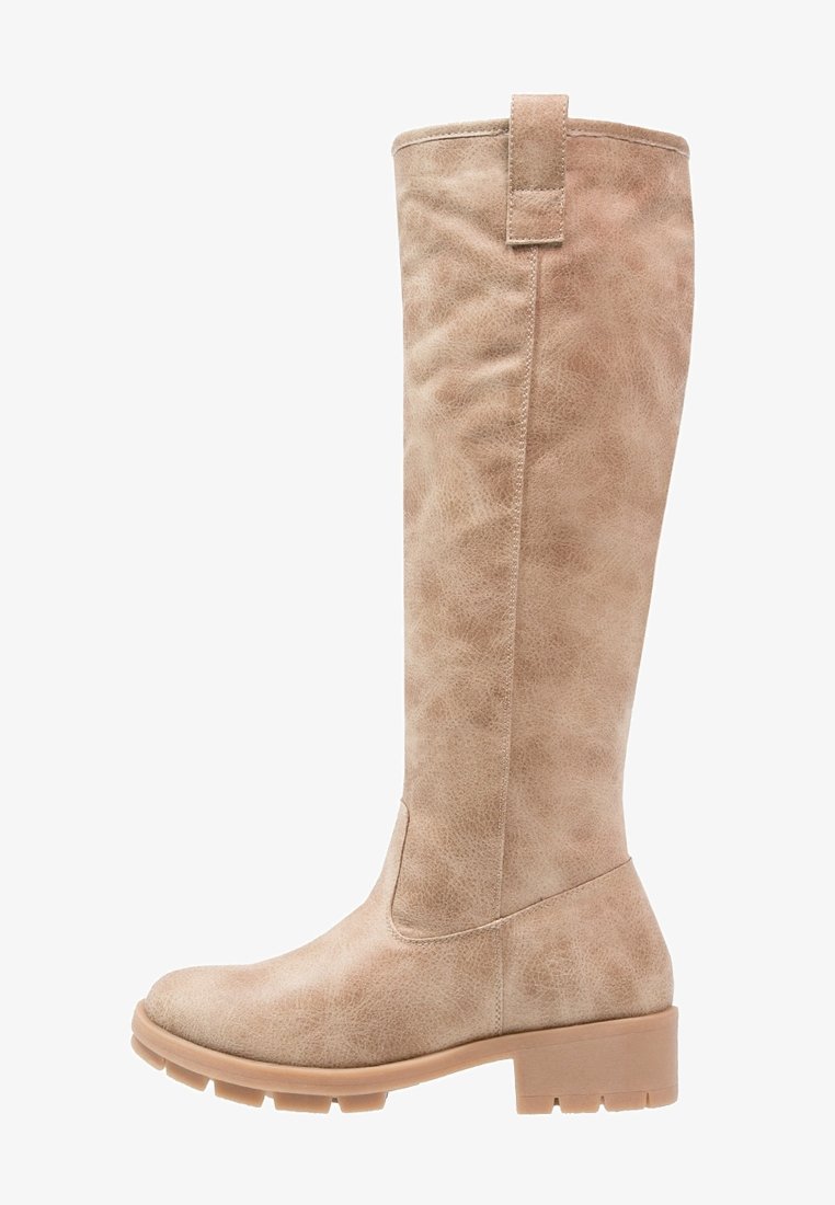 Botte haute en cuir beige avec languette, petit talon carré et semelle texturée, conçue pour un usage décontracté ou en plein air.