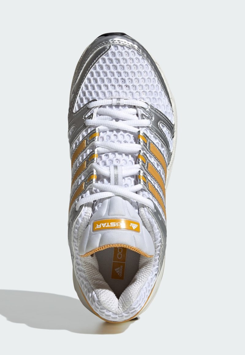 Chaussure de course en maille blanche avec des superpositions argentées, des rayures jaunes et un col matelassé, vue de dessus avec les lacets attachés.