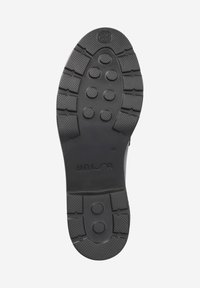 Suola di scarpa in gomma nera con motivi di grip testurizzati, borchie circolari e il nome del marchio "UNISA" impresso. Taglia "40" visibile.