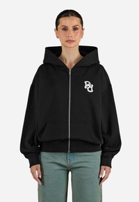 Felpa nera con zip, dalla vestibilità comoda, con tasche frontali, orlo e polsini ribattuti. Presenta un logo bianco nella zona sinistra del petto.