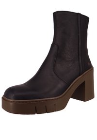 Botín de cuero negro con una gruesa suela de plataforma marrón, textura lisa y detalles de costura, que cuenta con un cremallera lateral y un ligero logotipo.