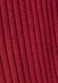 Tissu rouge côtelé avec une surface douce et texturée ; comporte des lignes verticales qui créent un motif structuré.