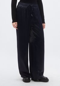 Tumši zilu platu bikšu audumu no satīna, ar elastīgu vidukļa joslu un auklu, gluda, spīdīga tekstūra.