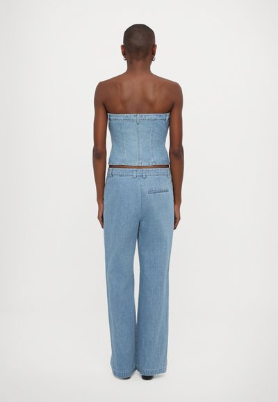 Denim strapless topp med en tettsittende bust og rette, høyt tilpassede vide bukser i lys blå, med baklommer og sømløst design.
