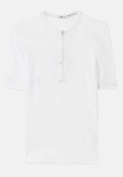 T-shirt blanc à manches courtes en tissu côtelé avec un col rond et une patte de boutonnage à cinq boutons. Texture douce et coupe décontractée.