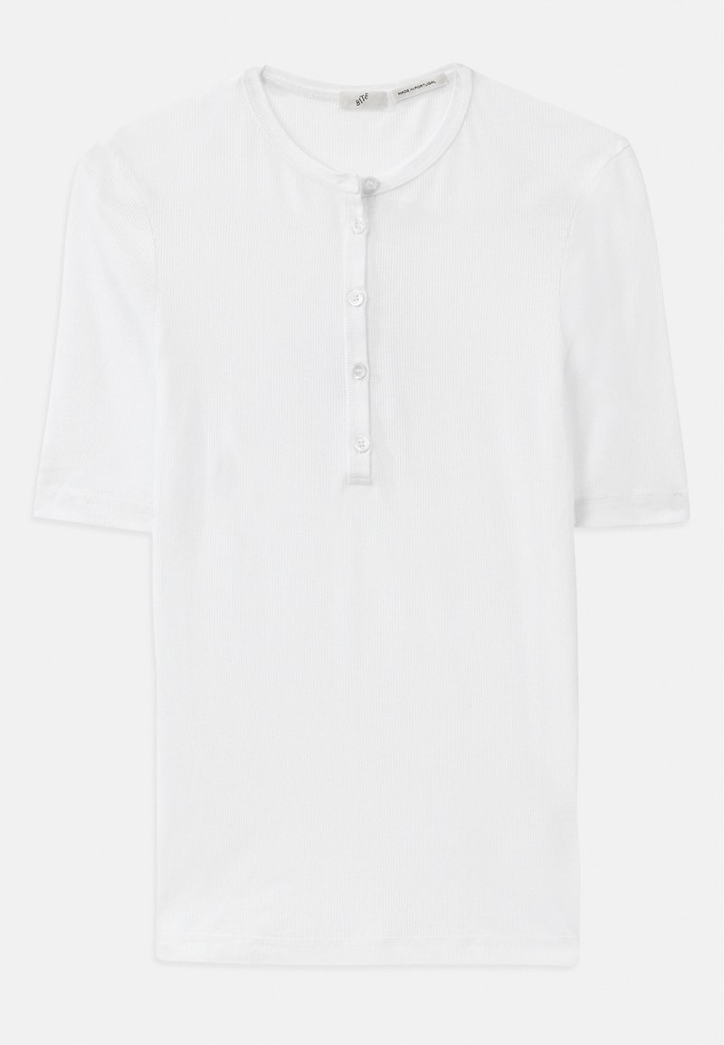 T-shirt bianco a maniche corte in tessuto a costine con scollatura rotonda e pattina con cinque bottoni. Texture morbida e vestibilità rilassata.