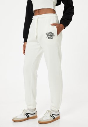 Witte sweatpants met geribde boorden, een trekkoord in de taille en zijzakken. Heeft een zwarte 'PARIS 1993' grafiek op de dij.