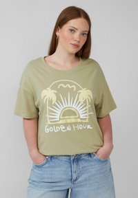 Olivegrünes T-Shirt mit kurzen Ärmeln und grafischem Design, das eine Sonne und Palmen zeigt, mit der Aufschrift "GOLDEN HOUR" in weißer Schrift.