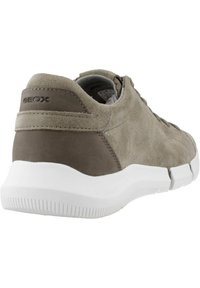 Graue Wildleder-Sneaker mit glattem Obermaterial, weißer Gummisohle und Logodetail an der Ferse. Verfügt über eine abgerundete Form und minimalistische Designelemente.