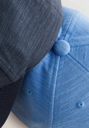 Dos gorras posicionadas juntas: una de color azul oscuro y otra de color azul claro, ambas hechas de un tejido texturizado con botones redondos en la parte superior y paneles cosidos.