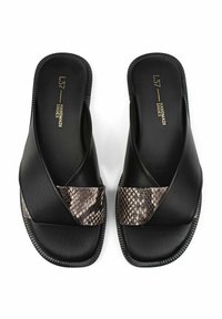 Sandali neri con crossover, realizzati in pelle liscia con un dettaglio in ecopelle effetto serpente. Suola piatta con bordi rigati.