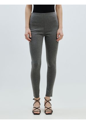 Grijze high-waisted leggings met verticale witte streepjes, met een aansluitend ontwerp en een zachte textuur. Draag met zwarte sandalen met bandjes.