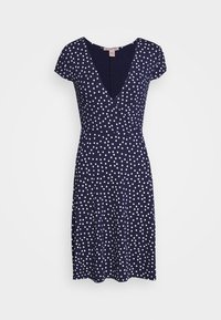 Marinblå knälång klänning med vita prickar, korta ärmar och en V-ringad omslagstopp.