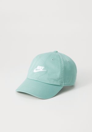 Mint green cotton baseball cap with a curved brim, featuring white Nike logo embroidery on the front and six ventilation eyelets.