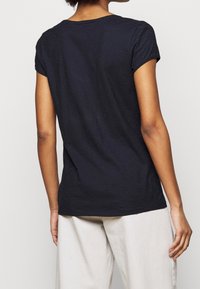 Navy short-sleeve T-shirt with a crew neckline, lightweight texture, and relaxed fit, shown from the back with plain design and subtle stitching.