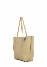 Sac fourre-tout en cuir beige avec deux longues anses, design structuré et finition texturée. Présente une étiquette bleue sur un côté.