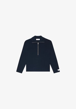 Pull-over long à manches en marine avec un col zippé, texture côtelée et petite étiquette logo sur la manche. Présente une coupe droite et décontractée.