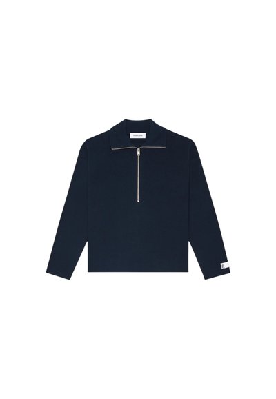 Pull-over long à manches en marine avec un col zippé, texture côtelée et petite étiquette logo sur la manche. Présente une coupe droite et décontractée.