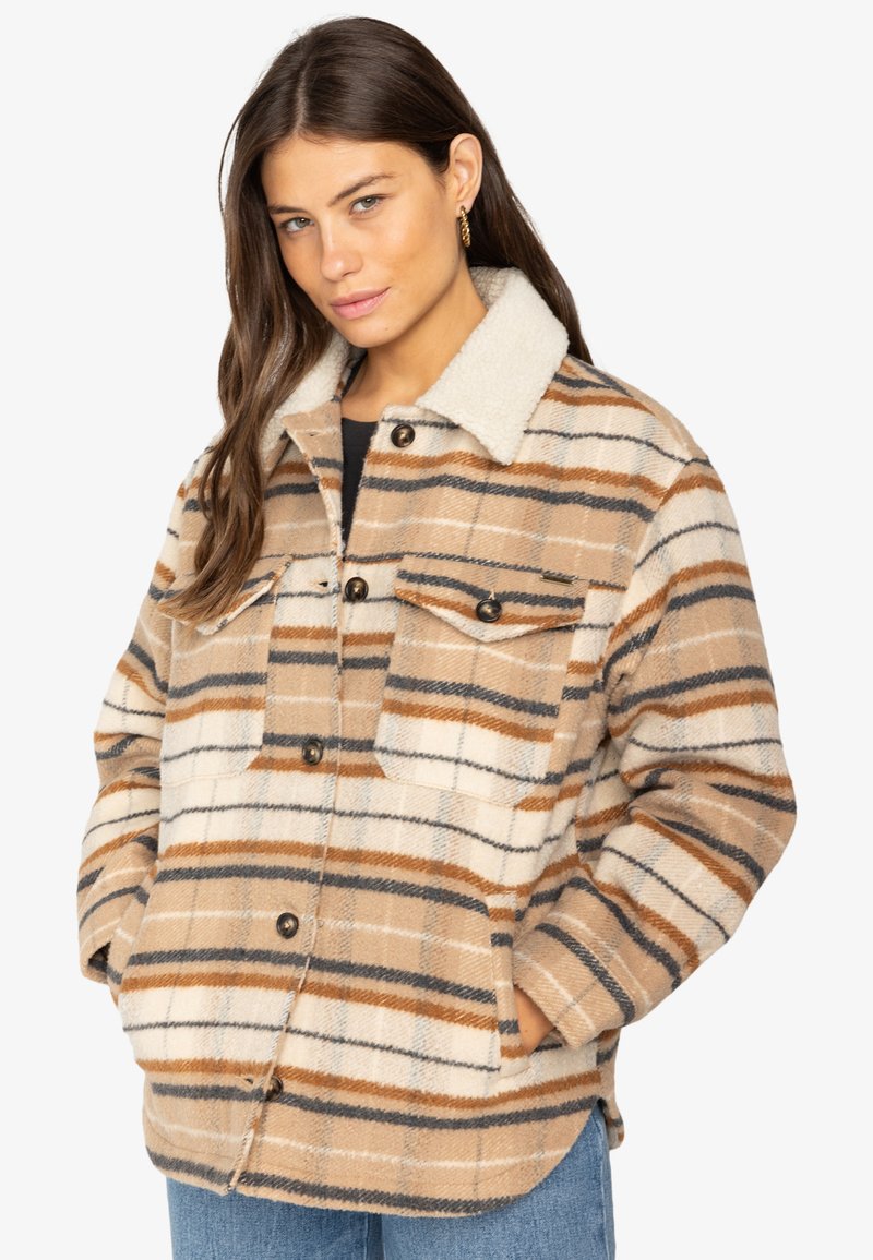 Bežová károvaná bunda so soft shearling golierom. Obsahuje hnedé a šedé pruhy, dve náprsné vrecká a gombíkové zapínanie. Textúrovaná tkanina.