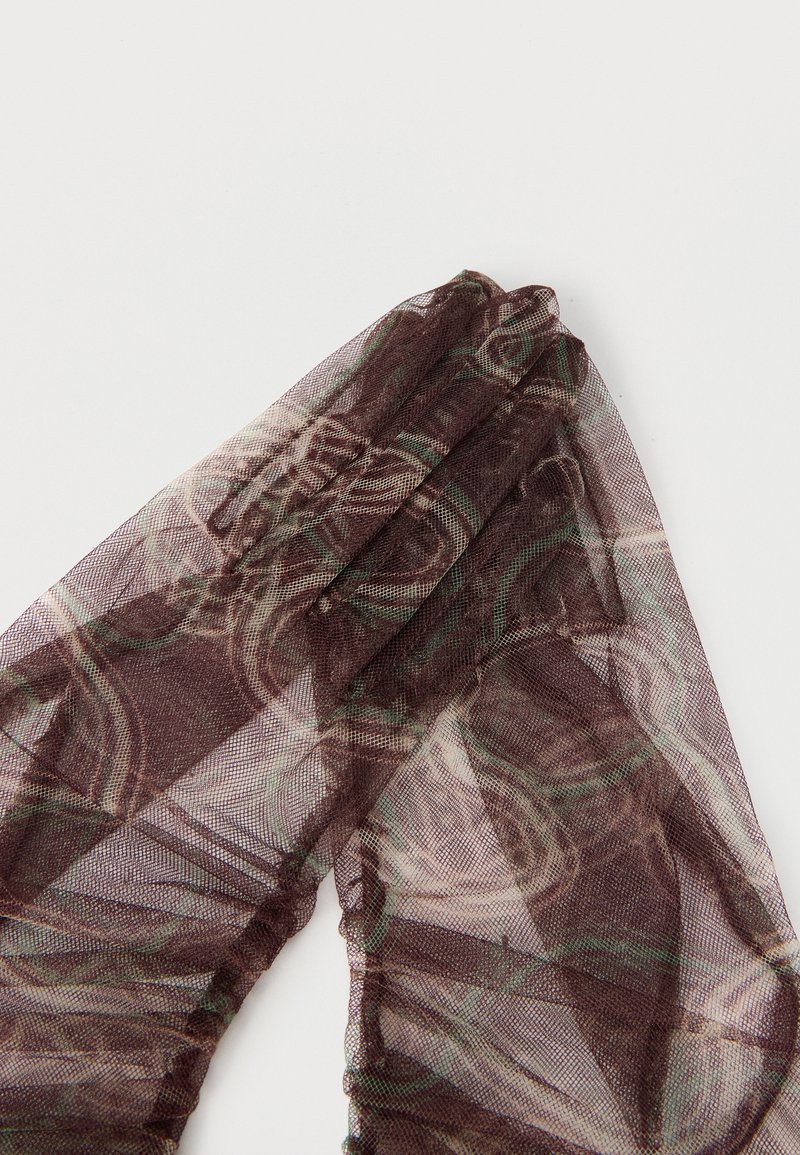 Tessuto a rete marrone trasparente con motivo, piegato su sfondo bianco, che mostra una texture traslucida e un design astratto a spirale.