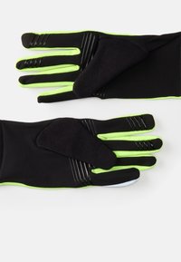 Svarta handskar med gröna detaljer, med en texturerad yta för grepp på handflator och fingrar, tillverkade av ett elastiskt material för flexibilitet.