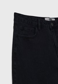Zwarte denimjeans met een klassieke pasvorm, een voorzak, een knoopsluiting en subtiele stikseldetails langs de tailleband en de zoom.