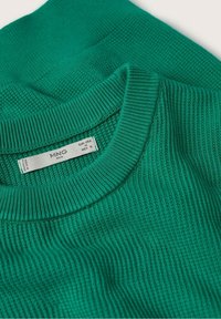 Grüner strukturierten Strickpullover mit geripptem Kragen und sichtbarem MNG Man Markenetikett, das Größe Medium für EUR, USA und MEX anzeigt.