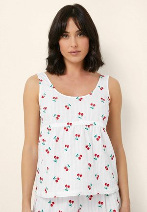 White sleeveless top with a scoop neckline, featuring red cherry patterns and green leaves, gathered at the waist for a relaxed fit.