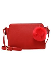 Czerwona torebka na ramię z ekologicznej skóry o prostokątnym kształcie, z regulowanym paskiem i dużym czerwonym pomponem przymocowanym z jednej strony.