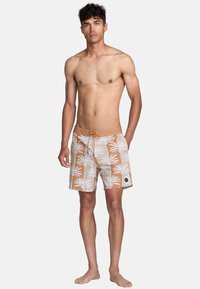 Brown swim trunks with white palm tree pattern, elastic waistband with drawstring, and a side logo patch. Designed for water activities.