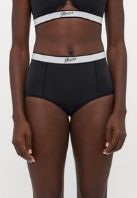 Cuecas altas pretas com uma faixa elástica cinza que exibe o logótipo da Puma. O material é suave e elástico, apresentando um design simples.