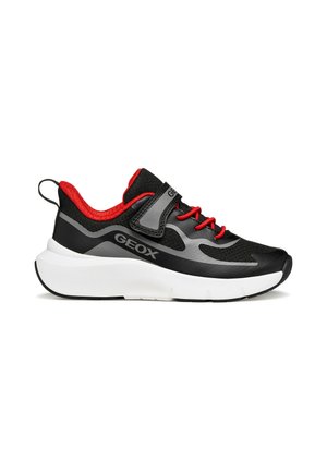 Zapatilla deportiva negra y roja con suela blanca gruesa, cordones rojos, detalles grises y logo "GEOX" en el lateral y la correa.