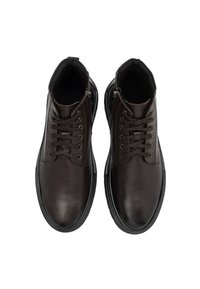 Zapatos de piel marrón con una textura suave, que cuentan con cordones y cremalleras. Punta redonda, collar acolchado y suela de goma para un buen agarre.