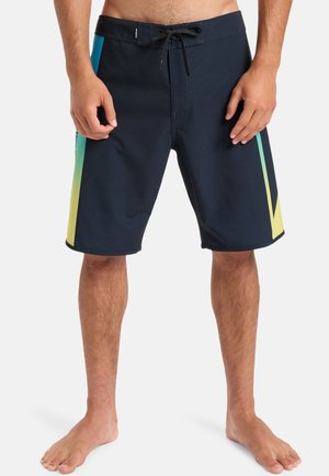 Marineblaue Boardshorts mit Kordelzugbund, die auf beiden Seiten leuchtend blaue und gelbe diagonale Akzente in einem Farbverlauf aufweisen.