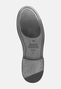 Schoenzool van glad zwart leer met een afgerond ontwerp, gegraveerd logo en metalen accentstuds langs de rand.