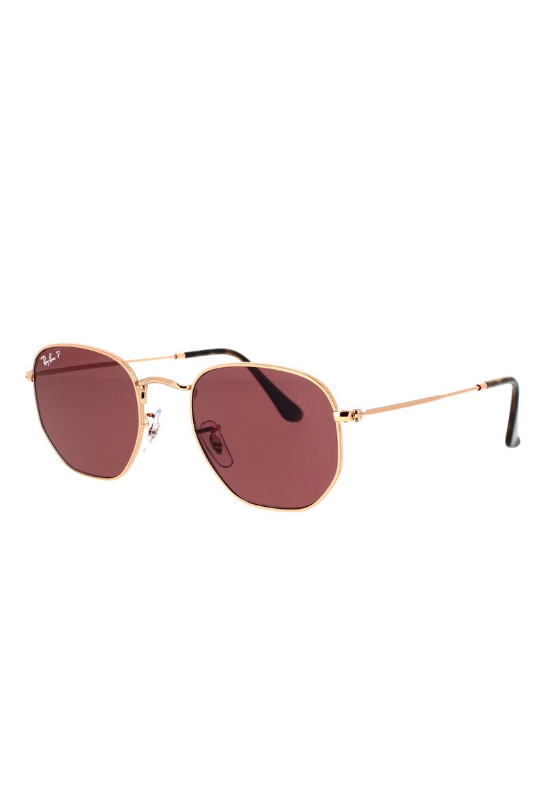 Occhiali da sole Ray-Ban con lenti ottagonali di un rosso scuro, montatura sottile in metallo dorato e aste nere. Presentano cuscinetti per il naso regolabili per il massimo comfort.