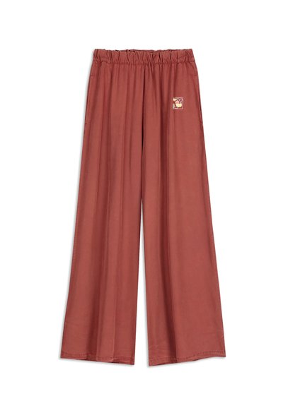 Brede roestkleurige broek met een elastische tailleband en een klein abstract patroon aan de rechterkant nabij de taille.