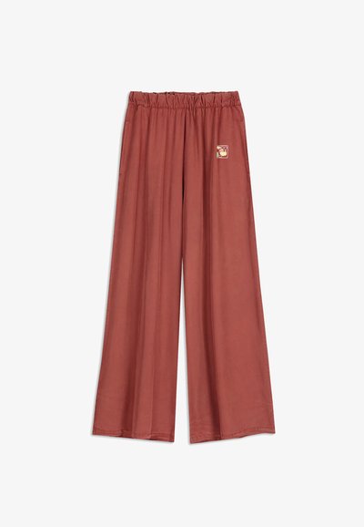 Brede roestkleurige broek met een elastische tailleband en een klein abstract patroon aan de rechterkant nabij de taille.