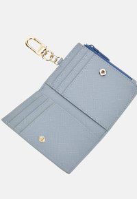 Portafoglio blu con texture, dotato di una chiusura dorata, numerosi scomparti per carte e un comparto con zip. L'interno è di un azzurro chiaro con una finitura liscia.