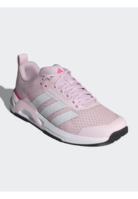 Svetlo roza športni čevelj z mrežastim zgornjim delom, tremi belimi črtami, teksturiranimi detajli in črnim gumijastim podplatom. Ima oblazinjen ovratnik in vezalke.