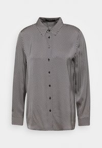 Långärmad skjorta med knappar i svart och vitt, med ett geometriskt mönster med rundade former, klassisk krage och svarta knappar.