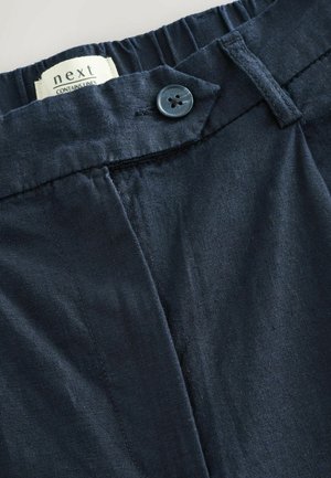 Pantaloni in lino blu scuro con vita elasticizzata, chiusura con un bottone e una superficie liscia con dettagli di cucitura minimi.