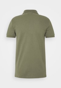 Polo vert olive avec un col à revers, manches courtes et tissu texturé. Présente un ourlet droit sans détails supplémentaires.