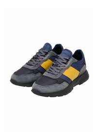 Zapatillas para hombres con una combinación de materiales en azul marino, gris y amarillo, con una parte superior de malla texturizada y suela de goma, diseñadas en una forma robusta.