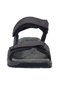 Brązowe sandały na otwartym palcu z dwoma regulowanymi paskami, wyściełaną wkładką oraz teksturowaną gumową podeszwą zapewniającą przyczepność.