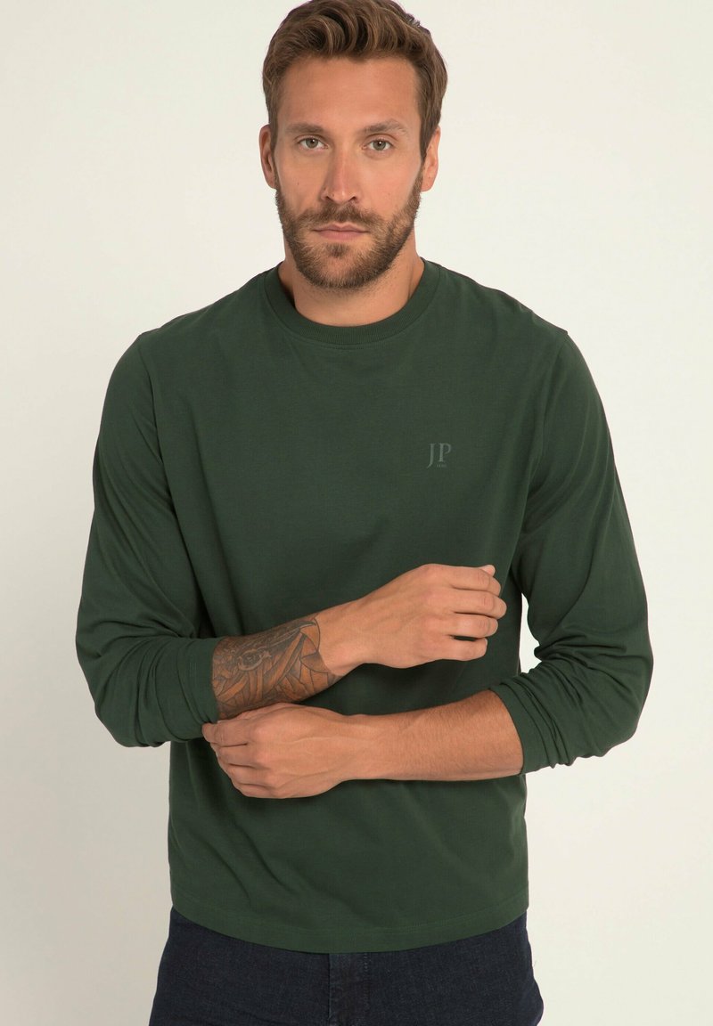 Langärmliges grünes T-Shirt aus weichem Stoff. Mit rundem Halsauschnitt und dezentem "JP"-Logo oben links. Glatte, ungemusterte Textur.