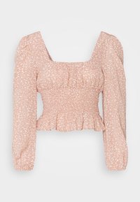 Haut court à manches longues rose blush avec taille smockée, décolleté carré, épaules bouffantes et subtil motif abstrait blanc.