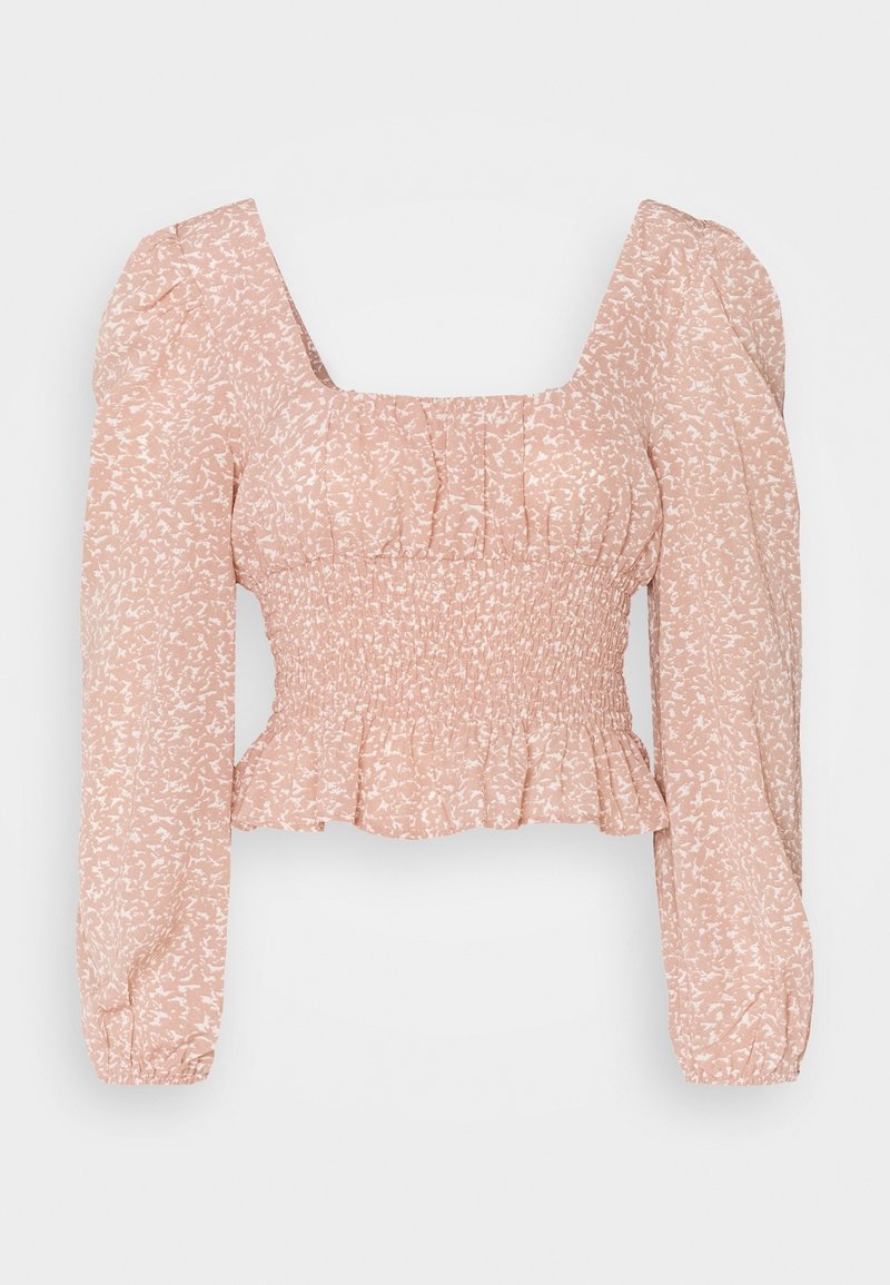 Haut court à manches longues rose blush avec taille smockée, décolleté carré, épaules bouffantes et subtil motif abstrait blanc.