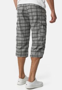Gråternet cargo shorts med knælangt design, sidelommer og opfoldede kanter, parret med hvide sneakers. Blend af bomuldsstof.
