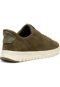 Zapatilla de ante verde con un upper texturizado y una suela blanca acolchada. Presenta un logo en el talón y cierre de cordones.
